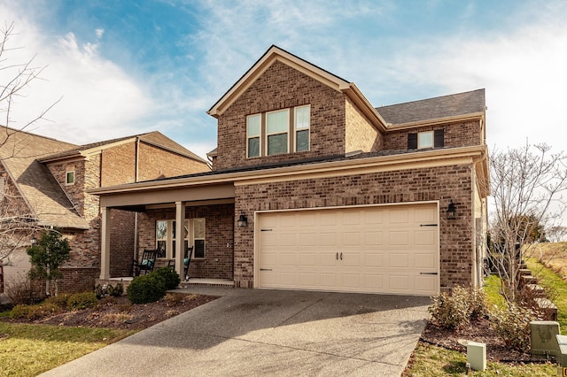 traditional home with driveway, a porch, an attached garage, and brick siding