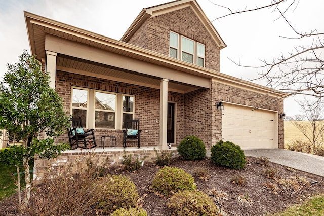 traditional-style house featuring covered porch, driveway, brick siding, and a garage