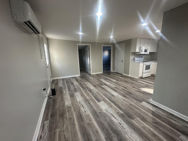 interior space featuring baseboards, dark wood finished floors, and a wall mounted air conditioner