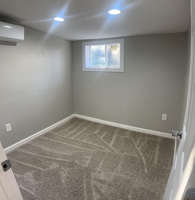 below grade area featuring carpet floors, recessed lighting, a wall unit AC, and baseboards