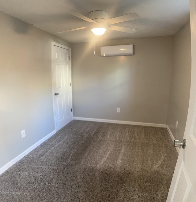 carpeted empty room with an AC wall unit, a ceiling fan, and baseboards