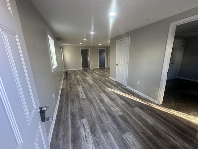 empty room with baseboards, dark wood finished floors, and recessed lighting