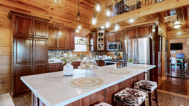 kitchen with wood ceiling, wooden walls, and appliances with stainless steel finishes