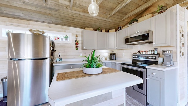 kitchen featuring vaulted ceiling with beams, light countertops, appliances with stainless steel finishes, white cabinets, and wooden ceiling