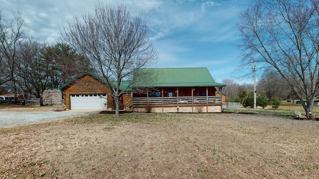 cabin featuring a garage, metal roof, and a porch