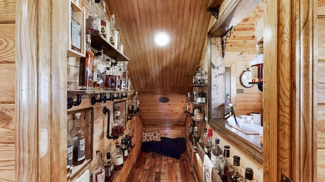 wine area featuring wooden ceiling, wood finished floors, and wooden walls