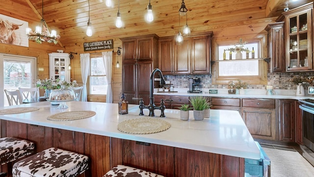 kitchen with light countertops, wood ceiling, a healthy amount of sunlight, and backsplash