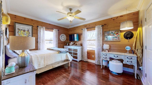 bedroom with crown molding, wooden walls, a ceiling fan, and wood finished floors