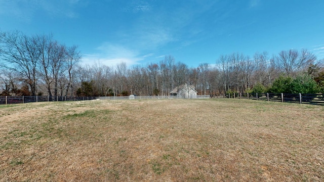 view of yard with fence and a rural view