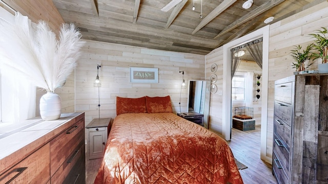 bedroom with wood ceiling, vaulted ceiling with beams, wooden walls, and wood finished floors