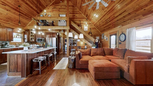 living room featuring wooden ceiling, stairway, dark wood finished floors, and a ceiling fan