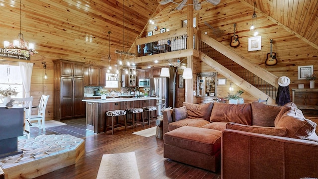 living area with dark wood-style floors, wood ceiling, wood walls, and stairway