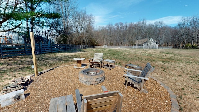 view of yard featuring an outdoor fire pit and fence