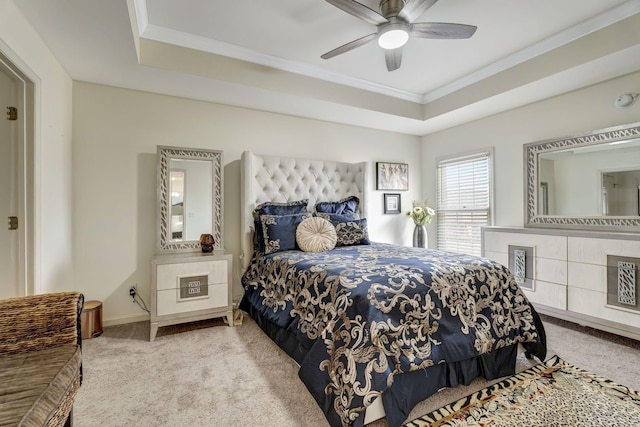 carpeted bedroom featuring ornamental molding, a tray ceiling, and ceiling fan