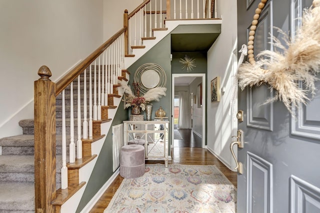 entrance foyer featuring a high ceiling, stairway, wood finished floors, and baseboards