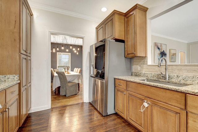 kitchen featuring dark wood-style flooring, stainless steel refrigerator with ice dispenser, decorative backsplash, ornamental molding, and a sink