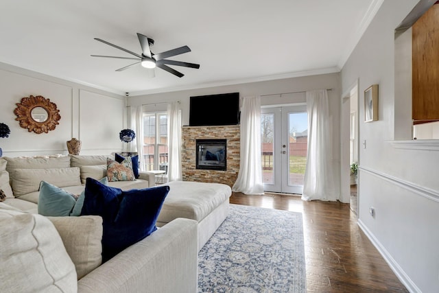 living area with plenty of natural light, ornamental molding, dark wood-type flooring, and french doors