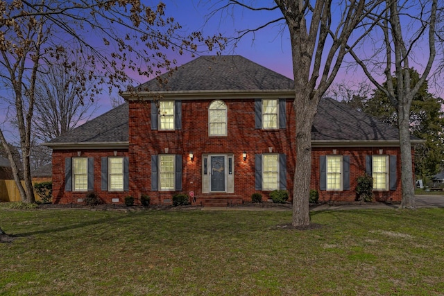 view of front of home with brick siding and a front lawn