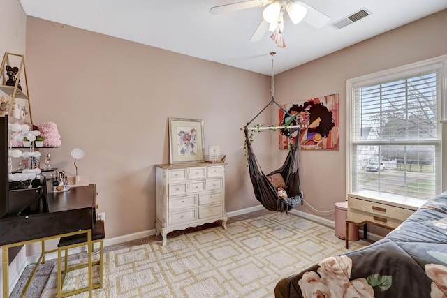 bedroom with a ceiling fan, visible vents, light carpet, and baseboards