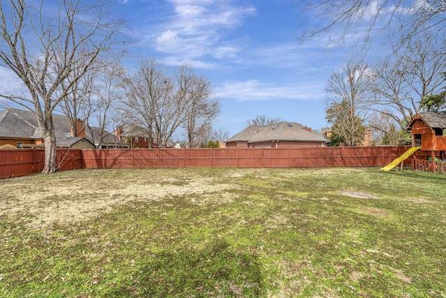 view of yard with a fenced backyard and a playground