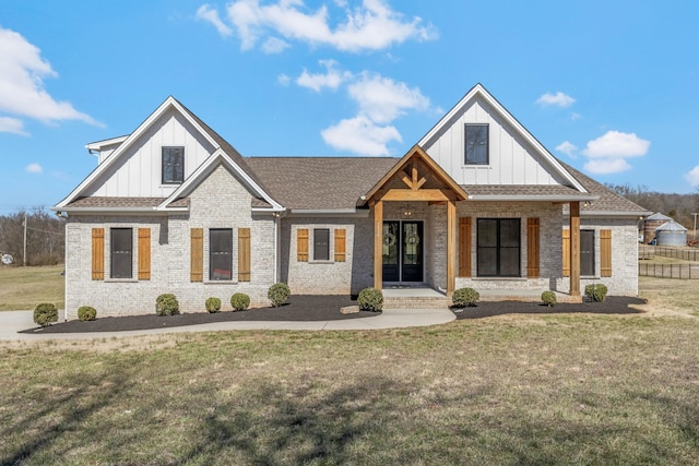 view of front of home featuring brick siding, board and batten siding, and a front yard