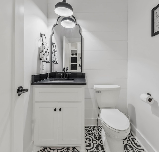 bathroom featuring tile patterned flooring, baseboards, vanity, and toilet