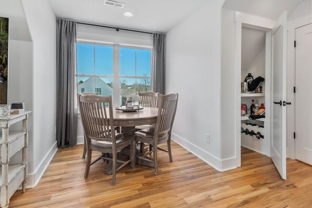 dining area featuring light wood-style flooring, visible vents, and baseboards