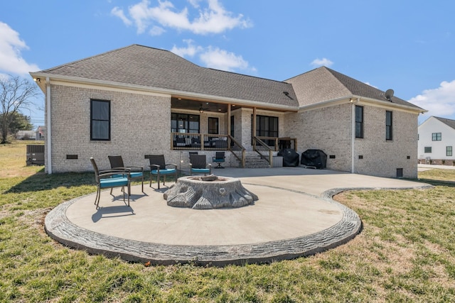 rear view of house with crawl space, a patio area, a lawn, and brick siding