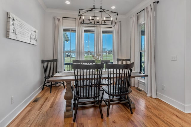 dining area with a chandelier, visible vents, light wood-style flooring, and baseboards