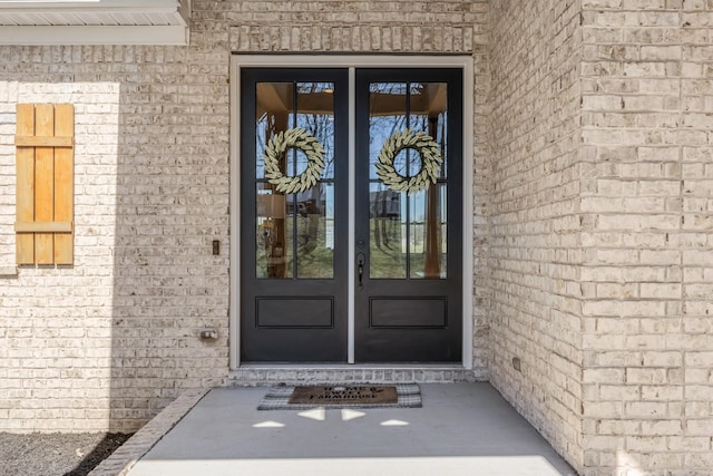 entrance to property featuring french doors and brick siding