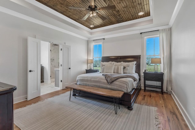 bedroom with a tray ceiling, wood finished floors, wood ceiling, and baseboards