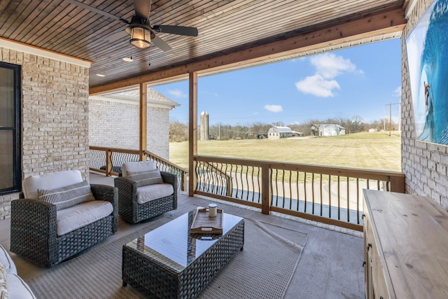 wooden terrace with outdoor lounge area, ceiling fan, and a lawn