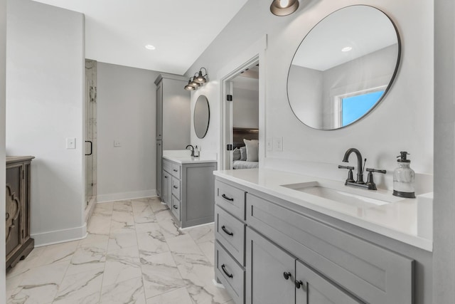 bathroom featuring marble finish floor, two vanities, a sink, a shower stall, and baseboards