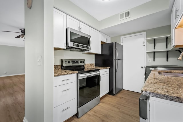 kitchen featuring visible vents, white cabinets, light wood-style flooring, appliances with stainless steel finishes, and a sink