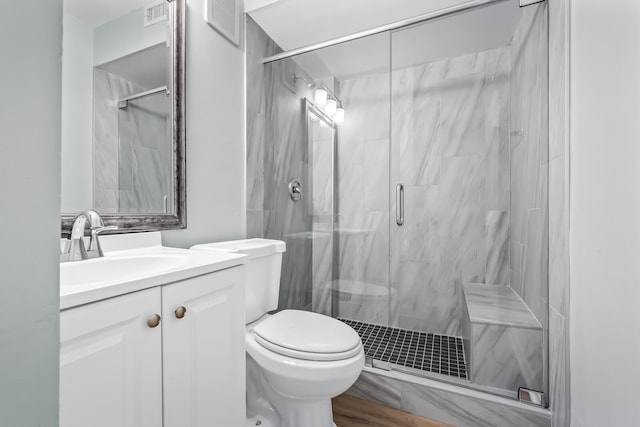 bathroom with vanity, a marble finish shower, and toilet