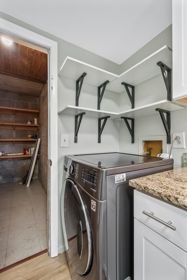 laundry area featuring light wood-style floors, washer hookup, wood ceiling, and cabinet space