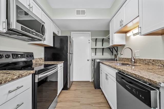 kitchen featuring visible vents, white cabinets, stainless steel appliances, stone counters, and a sink