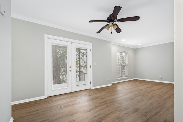 unfurnished room featuring baseboards, wood finished floors, crown molding, and french doors