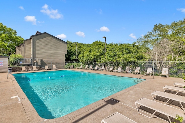 community pool featuring fence and a patio