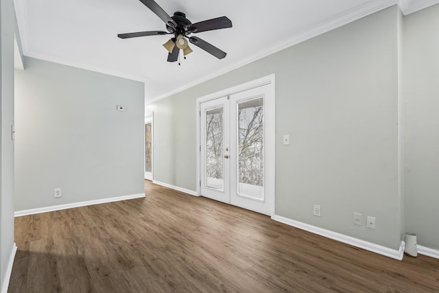 spare room featuring french doors, crown molding, baseboards, and wood finished floors