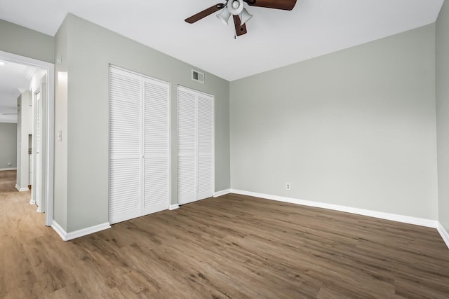 unfurnished bedroom with visible vents, baseboards, and wood finished floors