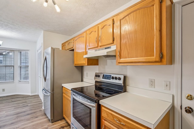 kitchen with a textured ceiling, light wood-style flooring, under cabinet range hood, stainless steel appliances, and light countertops