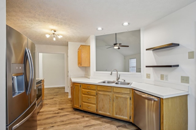 kitchen featuring open shelves, stainless steel appliances, light countertops, light wood-style flooring, and a sink