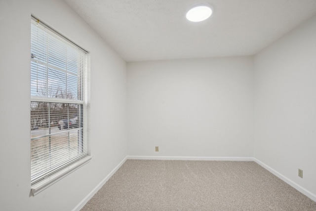 carpeted empty room with baseboards