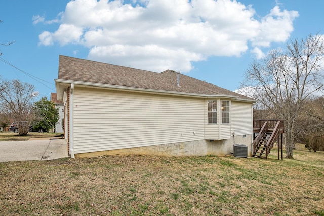 view of side of property with roof with shingles, a lawn, central AC, a wooden deck, and stairs