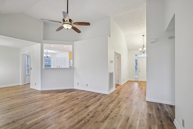 unfurnished living room featuring baseboards, wood finished floors, and ceiling fan with notable chandelier