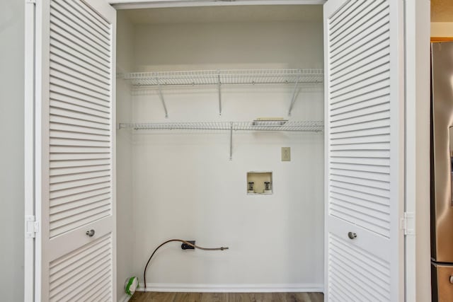 laundry area with laundry area, washer hookup, and wood finished floors