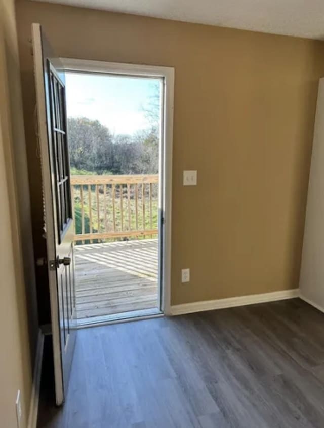 entryway with dark wood finished floors and baseboards