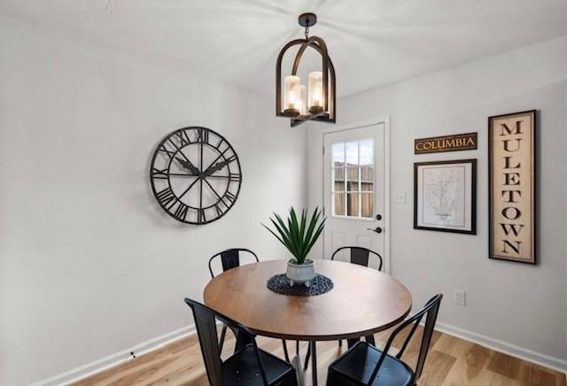 dining area featuring baseboards, a chandelier, and light wood-style floors