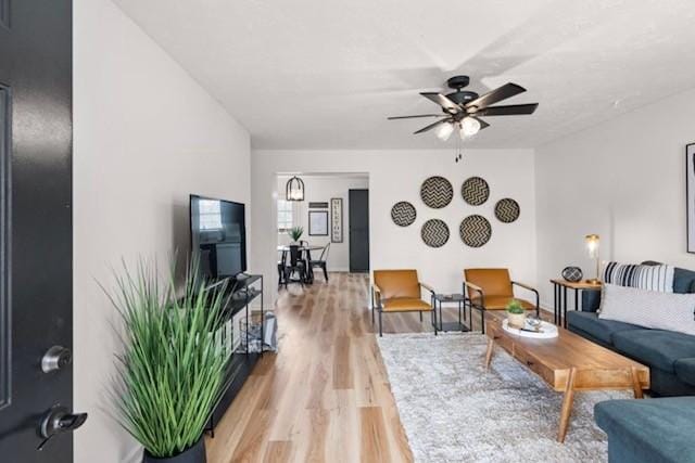 living room with light wood-type flooring and ceiling fan